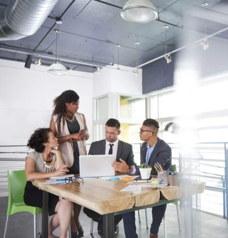 A group of people at work around a computer