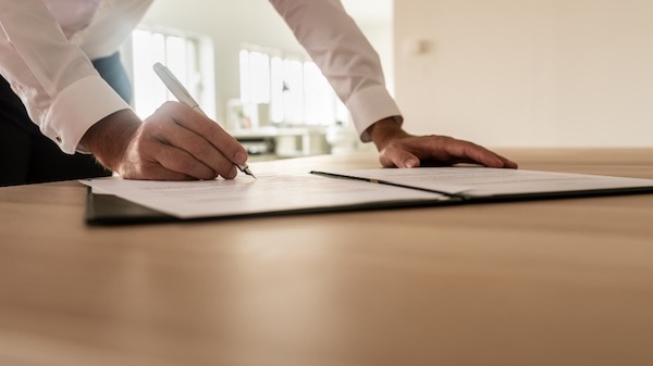 A person signing a document on a table