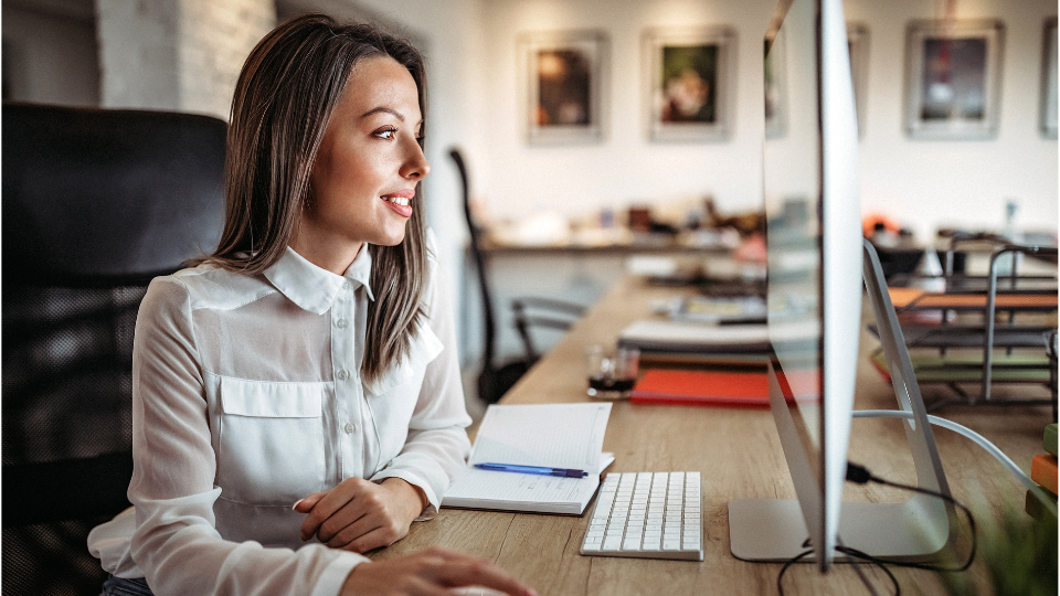  A person is sitting at a desk in front of a computer