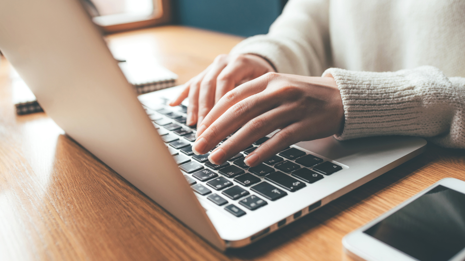 Close up of hands typing on a laptop