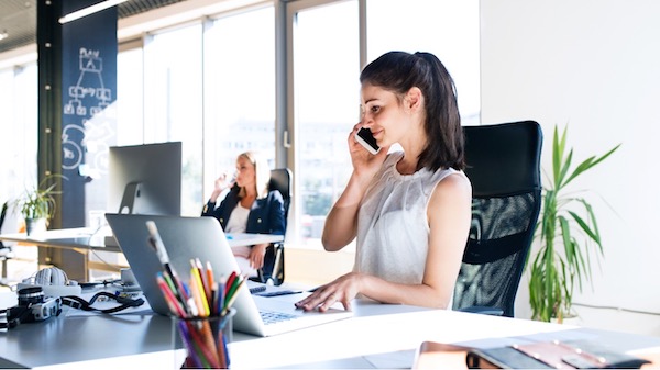 A person talking on the phone while sitting at a desk