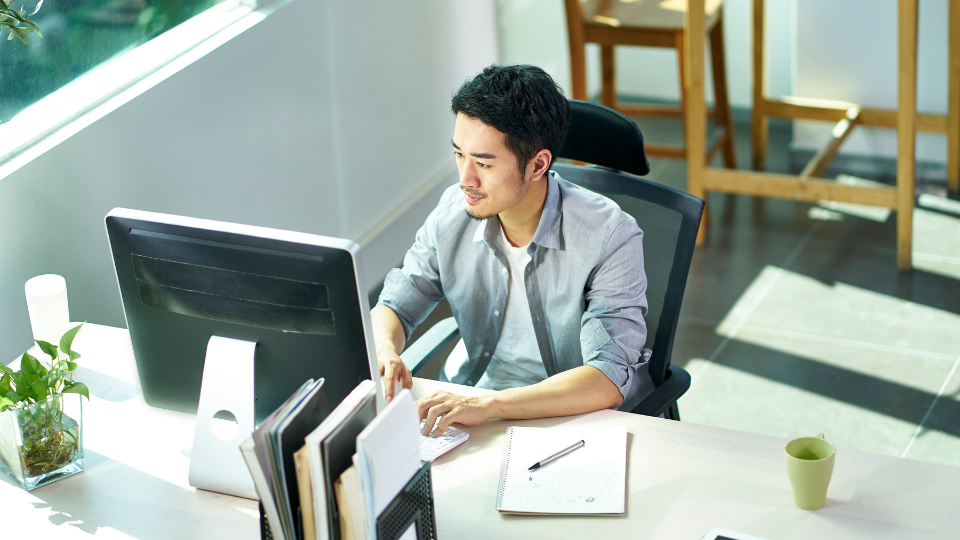 A person sitting at a desk in front of a computer