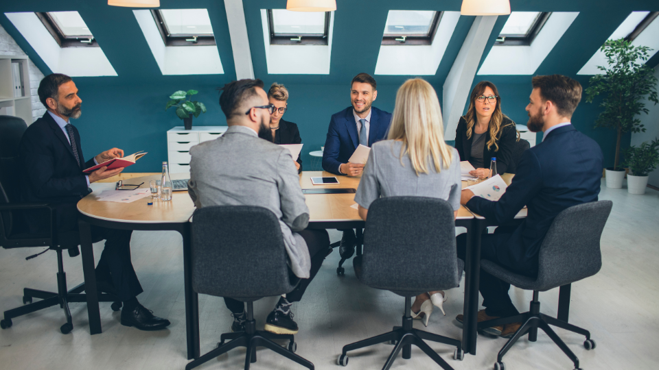 A group of business people sitting around a conference table