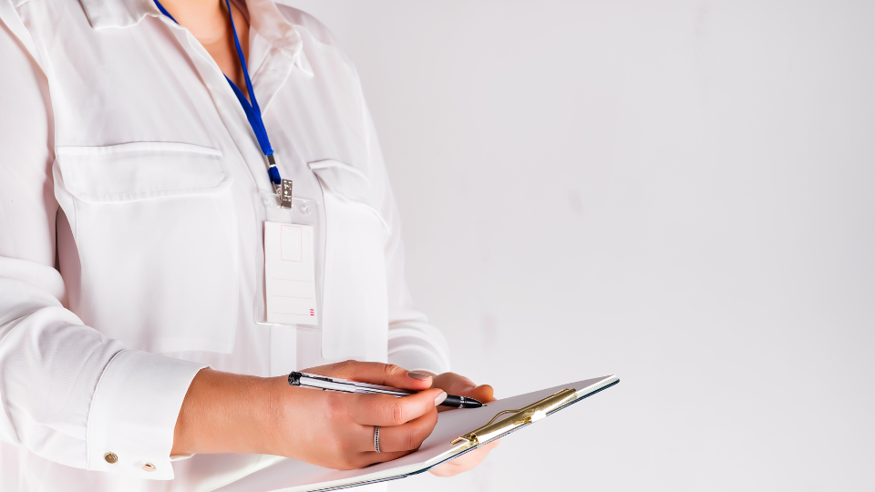 A person in a white shirt is holding a clipboard